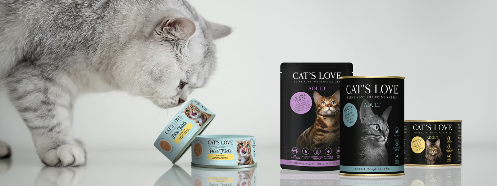 A cat smelling CAT'S LOVE fillets and CAT'S LOVE products next to it.